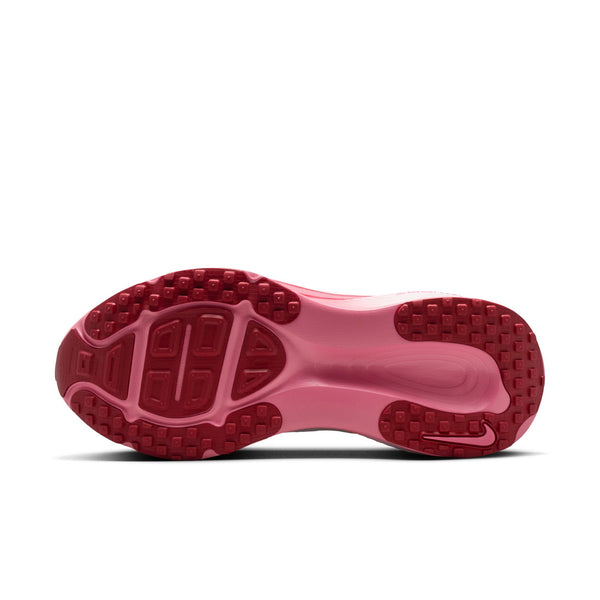 Close-up of a pink shoe sole with red tread pattern on a white background.