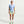 Person wearing a light blue t-shirt, green shorts, and white sneakers on a white background