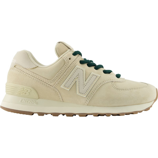 A New Balance sneaker in cream suede and leather with dark green laces, shown from on a white background.