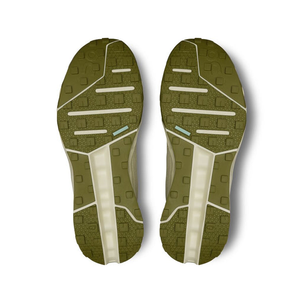 View of the outsole of a green trail shoe  with tread pattern on a white background.