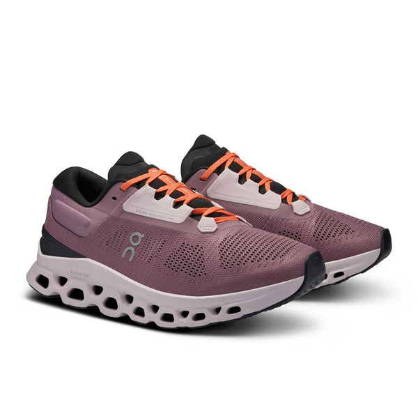 A pair of women's running shoes with orange laces and a black tongue.
