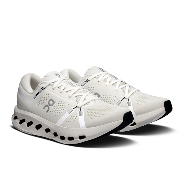 This pair of running shoes have an irory color to the upper and white shoe laces.