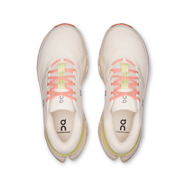 Pair of white running shoes with pink and yellow accents on a white background