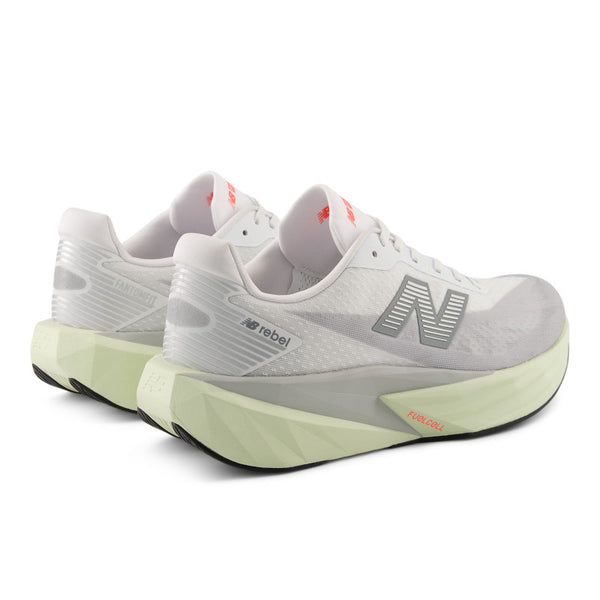 Mostly white running shoes from New balance with the name Rebel on the lateral side of the shoe with green sole on a white background.