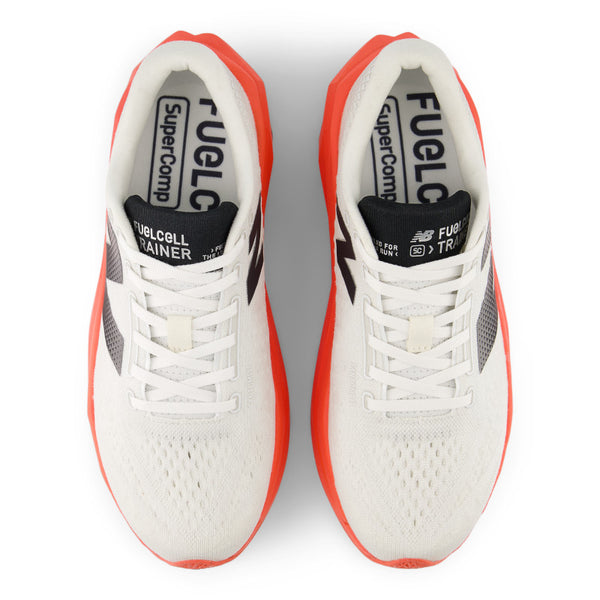 A pair of NB running shoes with a red midsoe and black tongue.