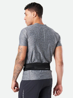 Person wearing a gray athletic shirt and black pants with a black belt on a white background