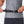 Person adjusting a black belt around their waist on a plain background