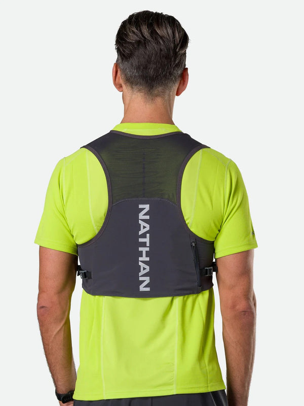 Person wearing a Nathan hydration vest on a white background
