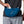 Person wearing a blue waist bag with 'Nathan' branding, holding a phone.