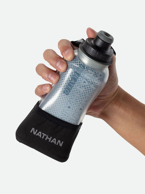 Hand holding a Nathan water bottle with a black sleeve against a white background