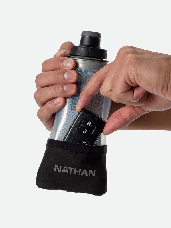 Person holding a Nathan water bottle pouch with a water bottle inside on a white background