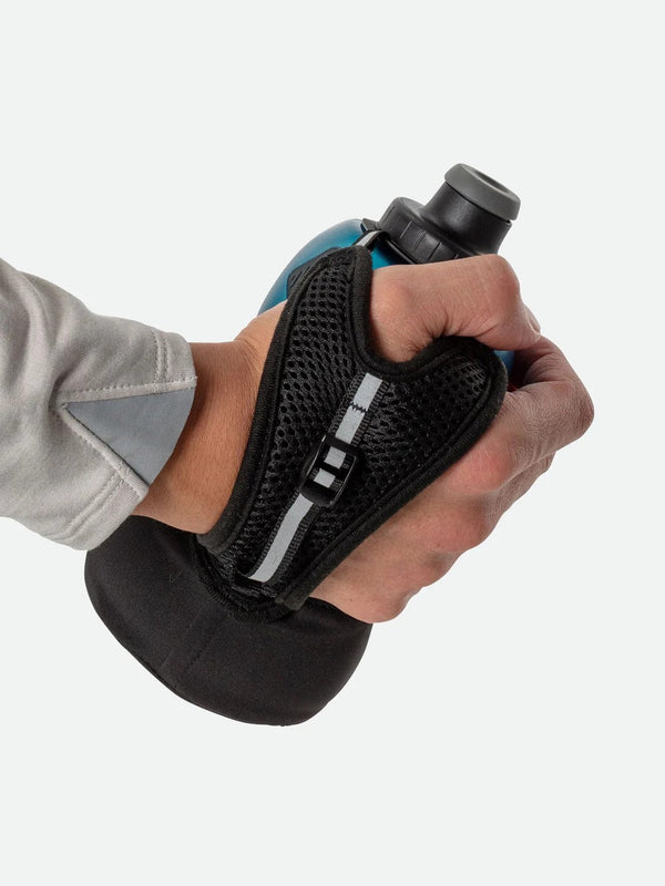Hand wearing a black glove holding a blue and black device on a white background