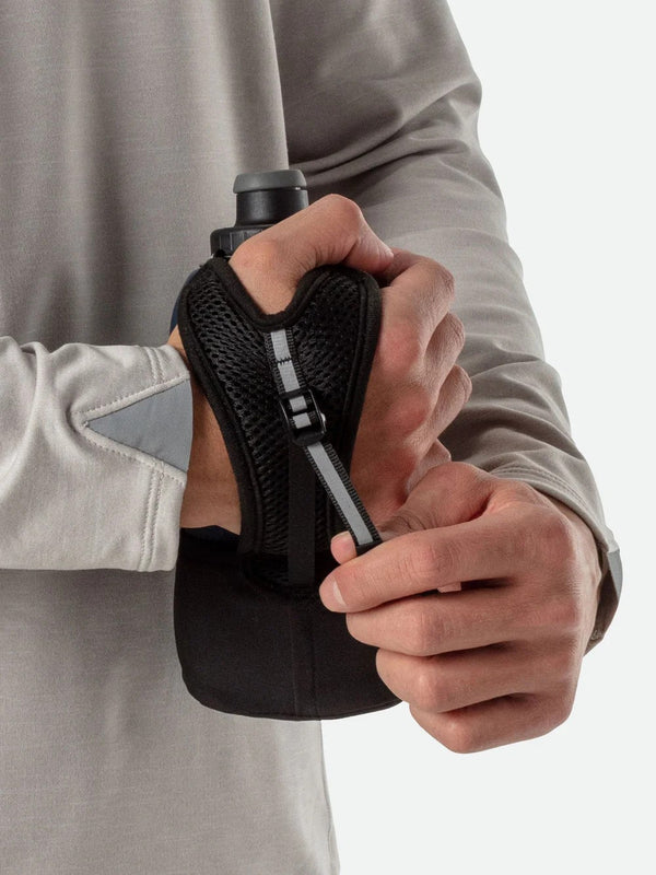Person holding a black and gray glove with a textured palm
