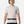 Man wearing a light gray t-shirt and black pants with a belt on a white background