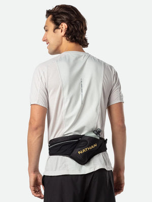 Person wearing a black waist bag with 'Nathan' branding on a white background