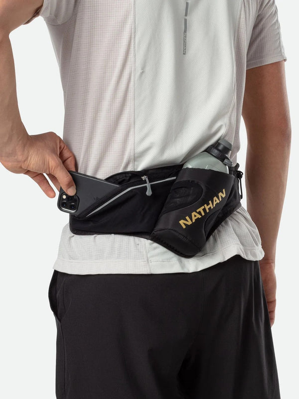 Person wearing a black waist bag with 'Nathan' branding on a white background