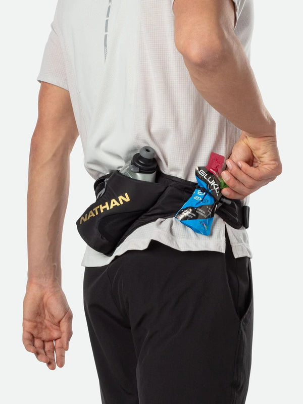 Person wearing a black hydration belt with Nathan and Elukta brands on a white background