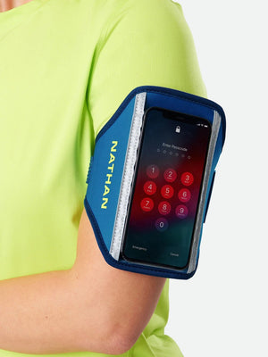 Nathan phone armband on a person's arm with a smartphone displaying a password screen.