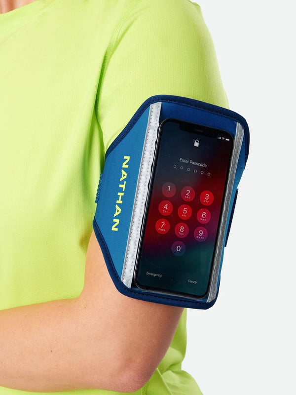 Nathan phone armband on a person's arm with a smartphone displaying a password screen.