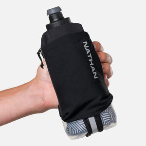 Black Nathan hydration bag held by a person against a white background