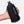 Black Nathan hydration bladder held in a hand against a white background