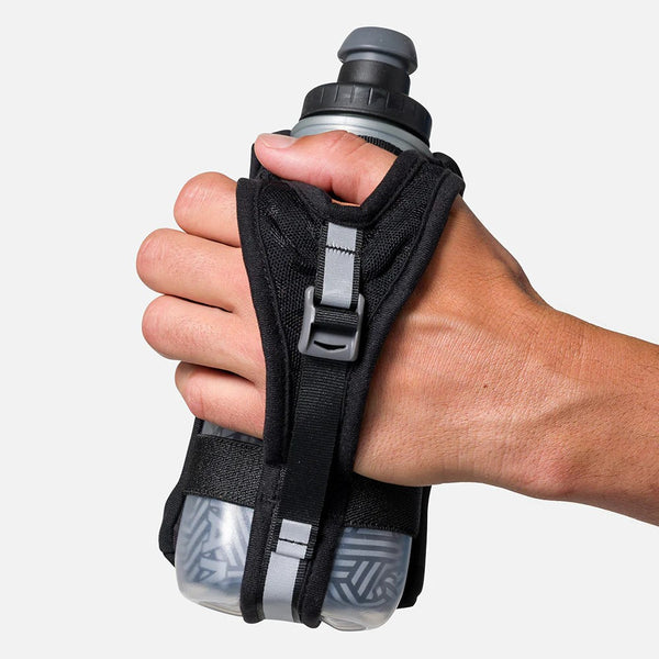 Hand holding a water bottle with a black grip and strap on a white background