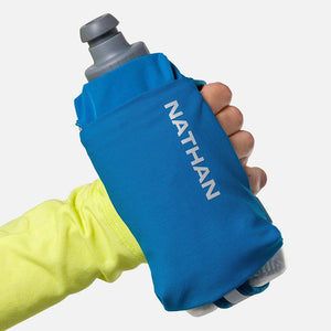 Blue Nathan hydration pouch held by a hand with a yellow sleeve on a white background
