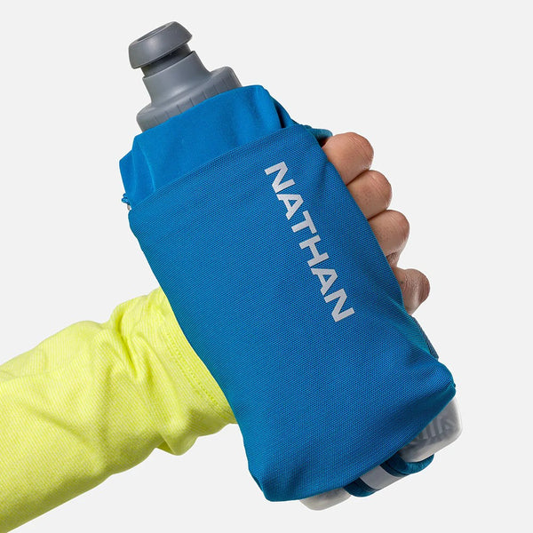 Blue Nathan hydration pouch held by a hand with a yellow sleeve on a white background