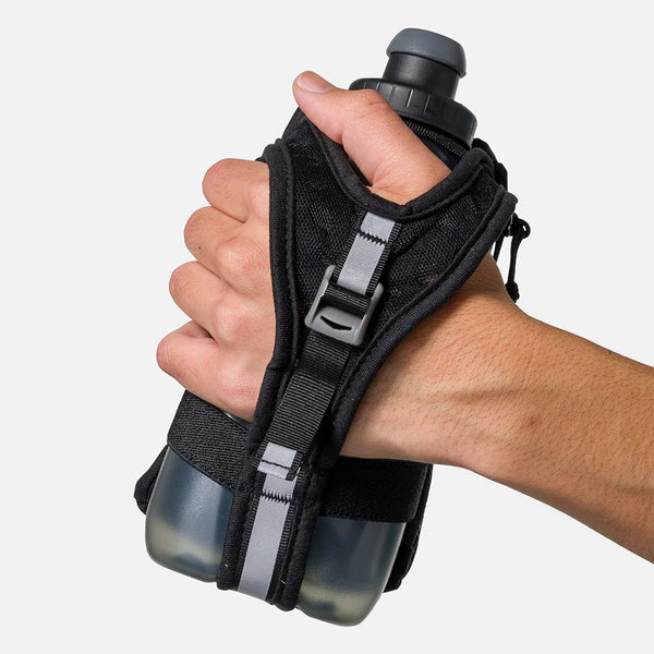 Hand holding a black wristlet with two water bottles against a white background