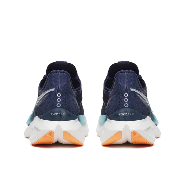 Pair of navy running shoes with orange soles on a white background
