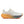 White running shoe with orange and gray sole on a white background
