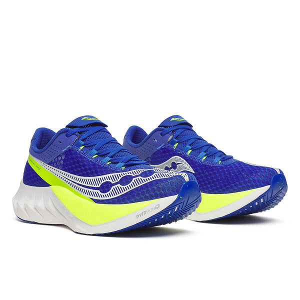 Blue and green Saucony running shoes on a white background and a blue outsole.