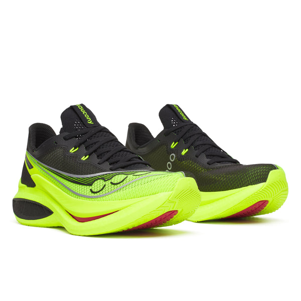 Black and neon green running shoes on a white background