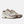 A New Balance athletic sneaker in beige, white, and brown, shown against a plain white background.
