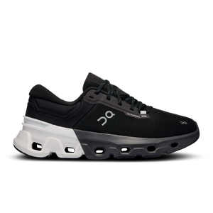 A pair of women's athletic shoes with a black upper and white sole, featuring a minimalistic design and branding on the side.
