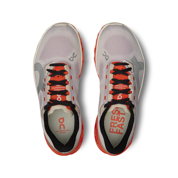 A pair of womens's running shoes with pops of oprange on a mostly grey shoe.