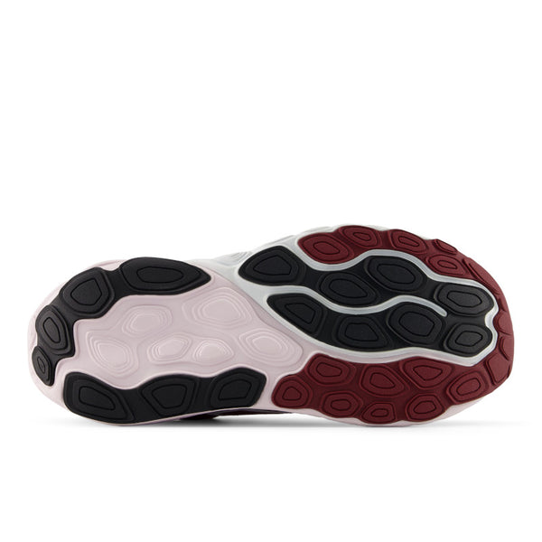 Close-up of a shoe sole with black, white, and red tread pattern on a white background