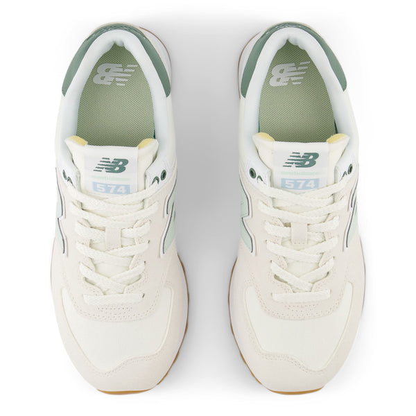 Pair of white sneakers with green accents on a white background