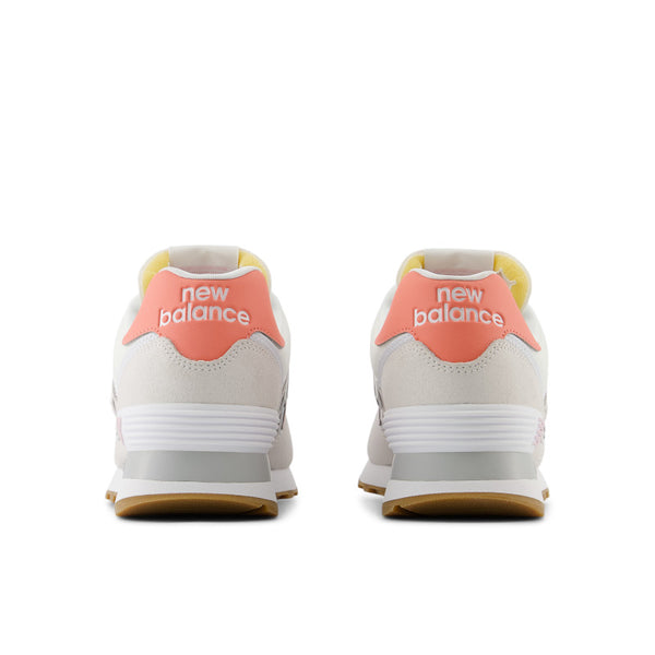 Mostly white women's New Balance 574 sneakers with pink accents.