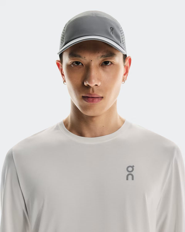 Person wearing a gray cap and white shirt with a brand logo on a white background