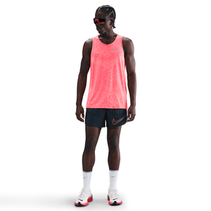 Person wearing a bright red tank top and black shorts with Nike logo on a white background