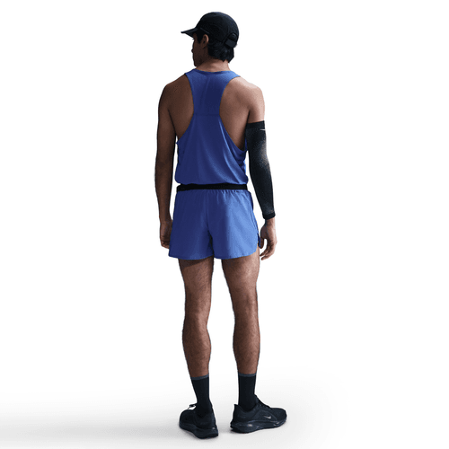 Person wearing a blue tank top and shorts on a white background