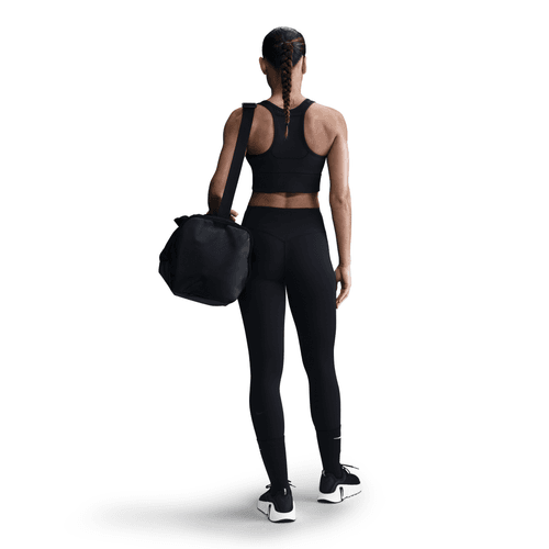 Person wearing black athletic wear holding a black bag on a white background