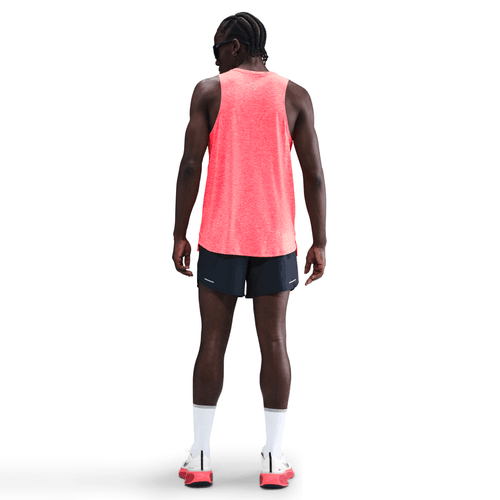 Person wearing a bright red tank top and black shorts on a white background