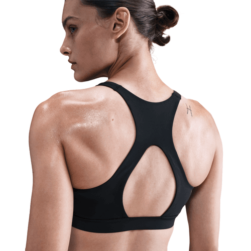 Woman wearing a black sports bra on a white background back view