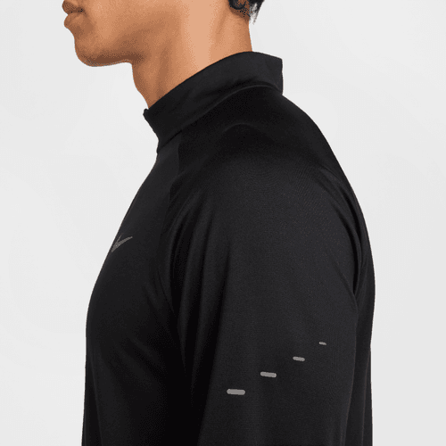 Side view of a person wearing a black long-sleeve athletic shirt on a light gray background