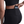 Person wearing black athletic leggings with a pocket holding a phone on a white background