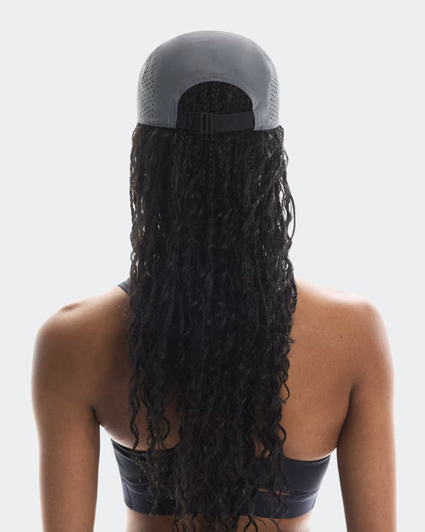 Person wearing a gray cap with a long braided ponytail on a white background