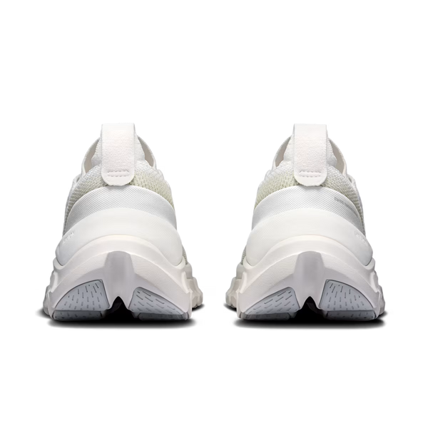 A pair of white and light gray athletic sneakers shown from the back, featuring chunky sculpted midsoles and textured outsoles, set against a plain white background.