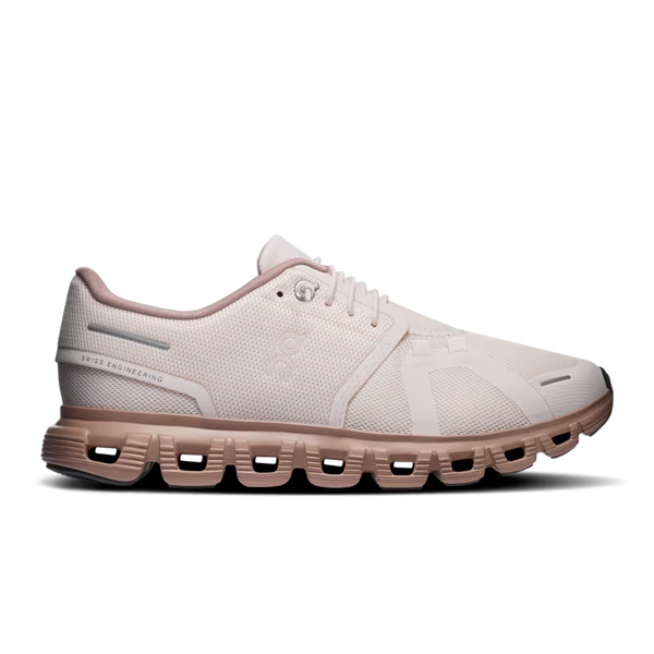 A single running shoe shown in a side profile on a clean white background. The shoe features a light off-white mesh upper with subtle tonal detailing, a pale pink collar lining, and a muted dusty rose midsole and outsole.